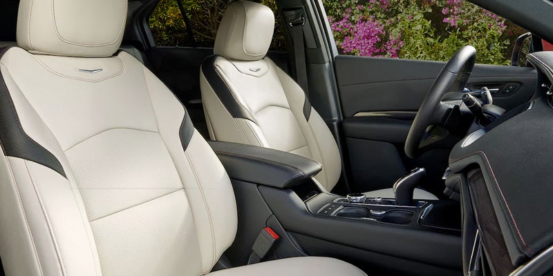 Interior of the Cadillac XT4 showcasing luxurious beige leather front seats with contrast stitching and a sleek dashboard design.