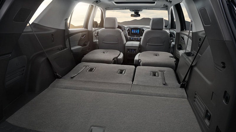 Interior view of a Chevrolet Traverse with the rear seats folded flat, showcasing the spacious cargo area.